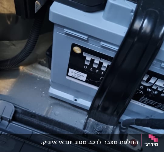 מצבר רכב עם כבלים מחוברים בתא המטען